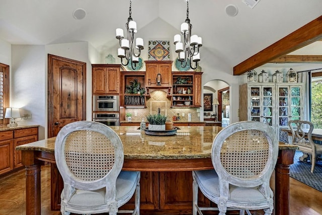 2600 Grapevine Springs Cv, Georgetown, TX 78628 - kitchen featuring open shelves, stainless steel double oven, lofted ceiling, tasteful backsplash, and arched walkways