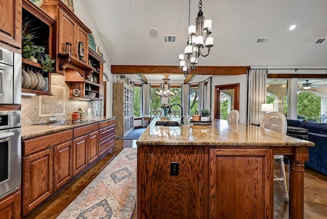 2600 Grapevine Springs Cv, Georgetown, TX 78628 - kitchen featuring a chandelier, open shelves, black electric cooktop, backsplash, and an island with sink