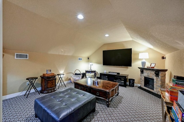 2600 Grapevine Springs Cv, Georgetown, TX 78628 - carpeted home theater room featuring baseboards, vaulted ceiling, a stone fireplace, recessed lighting, and a textured ceiling
