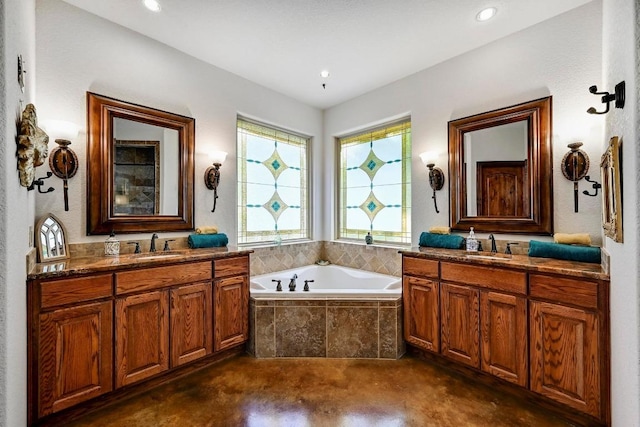2600 Grapevine Springs Cv, Georgetown, TX 78628 - bathroom featuring a garden tub, two vanities, recessed lighting, and concrete floors