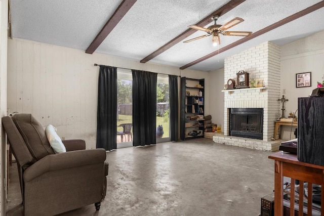 living room featuring a brick fireplace, beam ceiling, a textured ceiling, ceiling fan, and concrete flooring