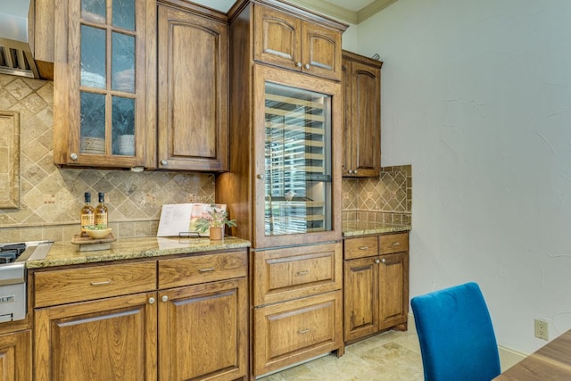 1186 Ranchers Club Ln, Driftwood, TX 78619 - kitchen with tasteful backsplash, glass insert cabinets, light stone counters, and brown cabinets