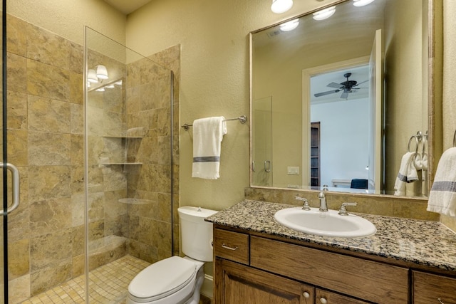 1186 Ranchers Club Ln, Driftwood, TX 78619 - bathroom featuring a stall shower, vanity, a textured wall, toilet, and ceiling fan