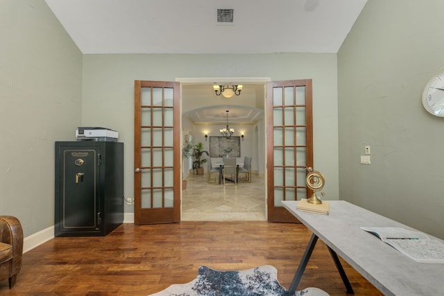 1186 Ranchers Club Ln, Driftwood, TX 78619 - office area with french doors, a chandelier, wood finished floors, arched walkways, and baseboards