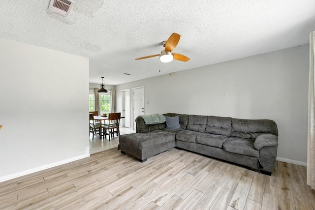 136 Shadow Oak Dr, Bastrop, TX 78602 - living area featuring light wood-type flooring, a ceiling fan, baseboards, and a textured ceiling