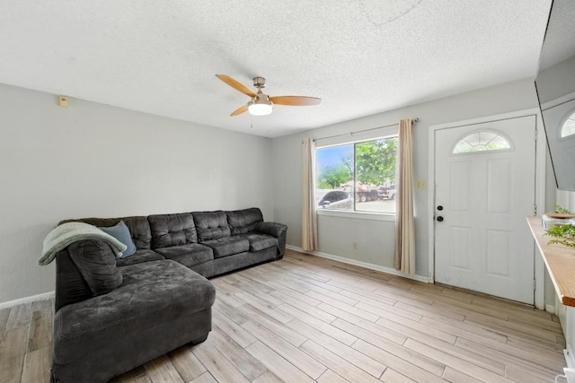 136 Shadow Oak Dr, Bastrop, TX 78602 - living area featuring ceiling fan, light wood finished floors, baseboards, and a textured ceiling