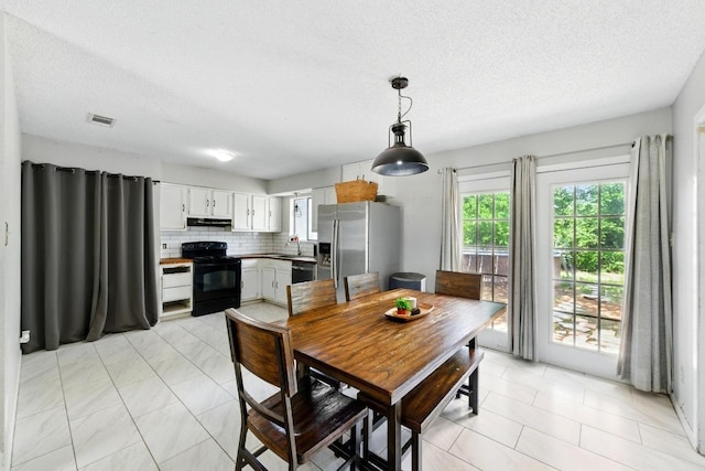 136 Shadow Oak Dr, Bastrop, TX 78602 - dining room with a textured ceiling and light tile patterned floors