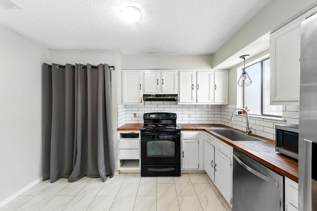 136 Shadow Oak Dr, Bastrop, TX 78602 - kitchen featuring wood counters, appliances with stainless steel finishes, a sink, range hood, and a textured ceiling