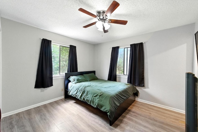 136 Shadow Oak Dr, Bastrop, TX 78602 - bedroom featuring wood finished floors, baseboards, a textured ceiling, and ceiling fan