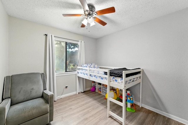 136 Shadow Oak Dr, Bastrop, TX 78602 - bedroom featuring wood finished floors, baseboards, a textured ceiling, and ceiling fan