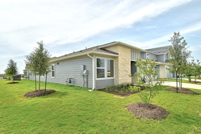 17129 Loch Rd, Pflugerville, TX 78660 - view of home's exterior with a lawn, stone siding, driveway, and a garage