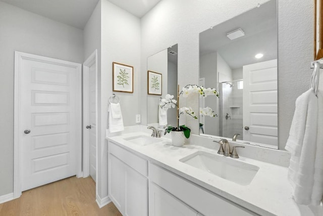 17129 Loch Rd, Pflugerville, TX 78660 - full bath featuring double vanity, a shower stall, and wood finished floors