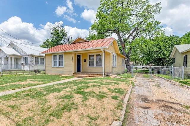 view of front of house featuring a standing seam roof, a gate, and metal roof