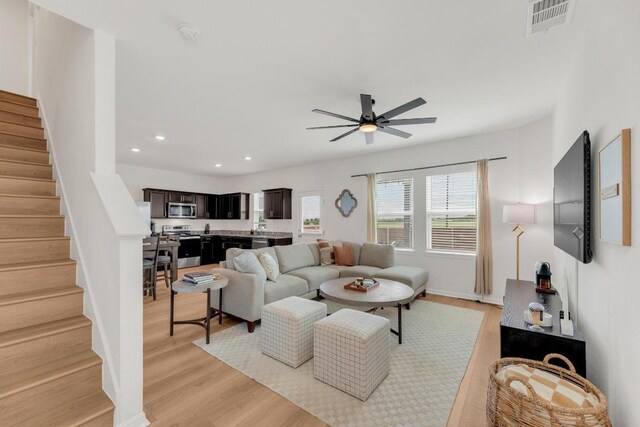 17913 Shafer Dr, Pflugerville, TX 78660 - living area with a ceiling fan, stairs, light wood-style flooring, recessed lighting, and baseboards