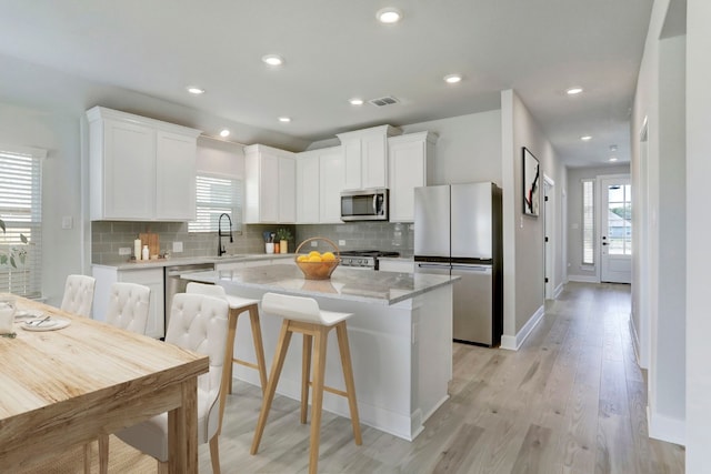 9721 Eloquence Dr, Manor, TX 78653 - kitchen with stainless steel appliances, plenty of natural light, a sink, white cabinets, and recessed lighting