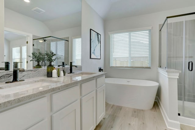 9721 Eloquence Dr, Manor, TX 78653 - bathroom with a stall shower, wood finished floors, double vanity, and lofted ceiling
