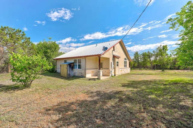 195 Live Oak, Liberty Hill, TX 78642 - rear view of property with stone siding, a yard, and metal roof
