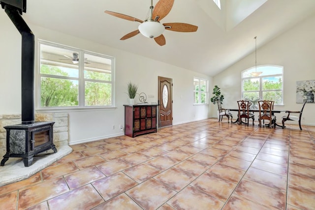 195 Live Oak, Liberty Hill, TX 78642 - living area with a wood stove, a ceiling fan, high vaulted ceiling, light tile patterned floors, and baseboards