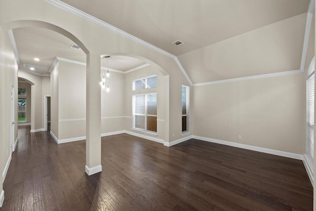 unfurnished living room with dark wood finished floors, baseboards, crown molding, and arched walkways