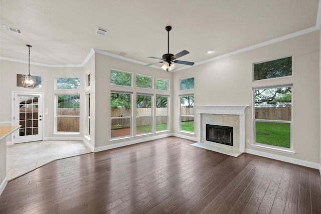 3408 Reims Ct, Austin, TX 78738 - unfurnished living room featuring ornamental molding, a fireplace, healthy amount of natural light, and hardwood / wood-style floors