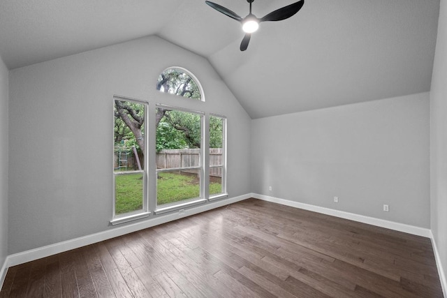 additional living space with vaulted ceiling, a ceiling fan, dark wood-type flooring, and baseboards