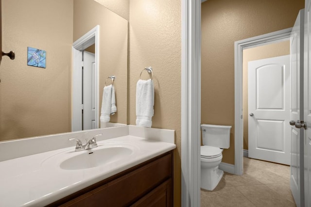 bathroom featuring toilet, tile patterned floors, and vanity