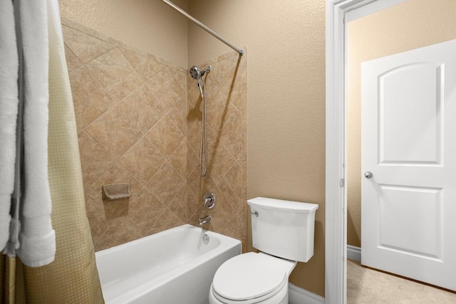 bathroom featuring shower / bath combination with curtain, a textured wall, and toilet