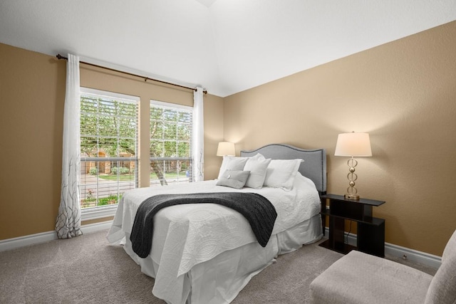 carpeted bedroom with baseboards and vaulted ceiling