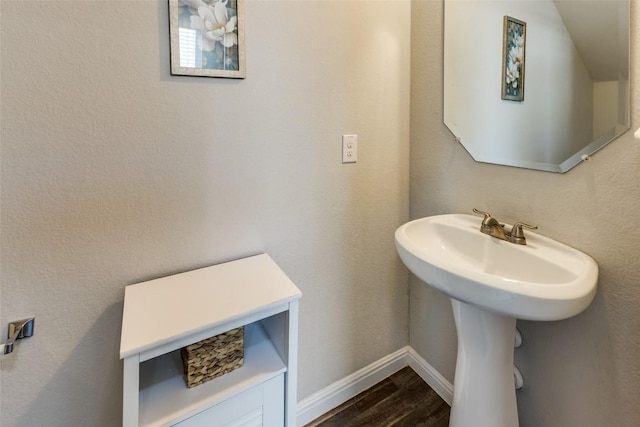 bathroom featuring wood finished floors and baseboards