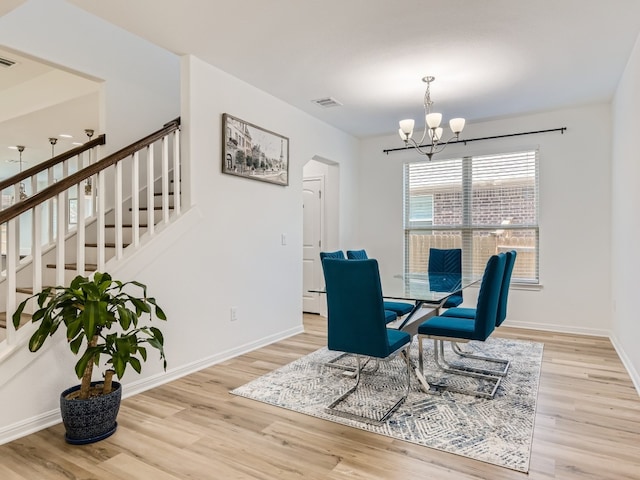 4325 Arques Ave, Round Rock, TX 78681 - dining space with wood finished floors, a chandelier, stairway, and baseboards