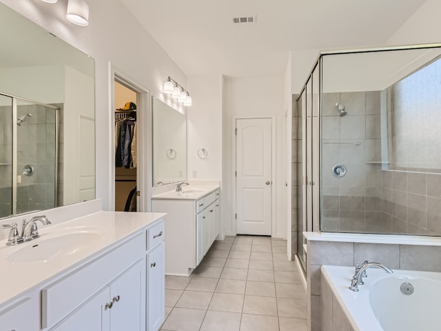 4325 Arques Ave, Round Rock, TX 78681 - bathroom with a shower stall, two vanities, tile patterned floors, a garden tub, and a spacious closet