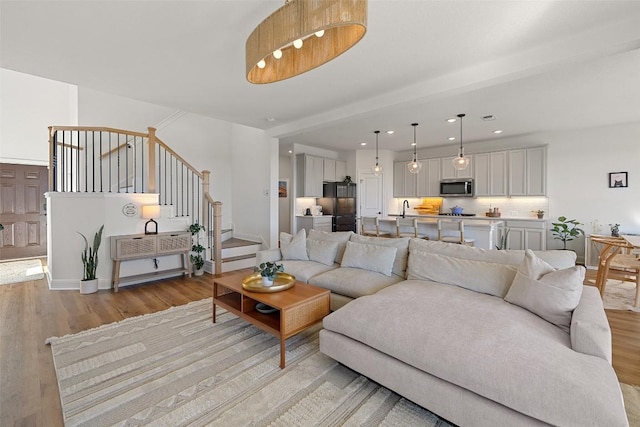 424 Turnbuckle Bnd, Leander, TX 78641 - living room featuring light wood-type flooring, stairway, and recessed lighting