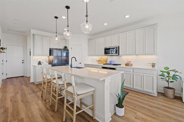424 Turnbuckle Bnd, Leander, TX 78641 - kitchen with freestanding refrigerator, stainless steel microwave, tasteful backsplash, recessed lighting, and a breakfast bar area