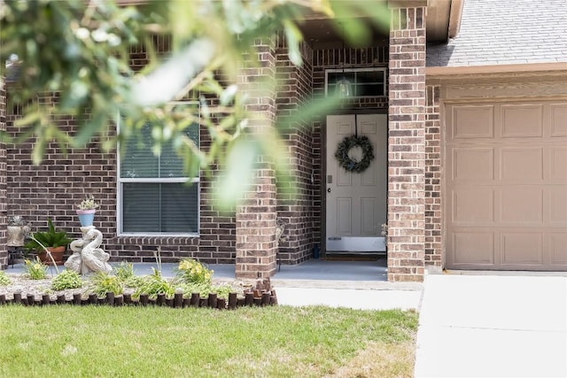 entrance to property featuring brick siding and an attached garage