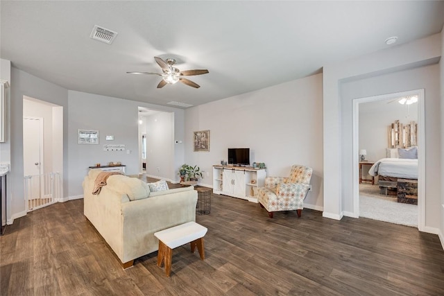 living room with ceiling fan, dark wood-type flooring, and baseboards