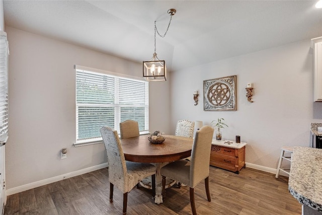 dining space featuring baseboards, a chandelier, and light wood-style flooring