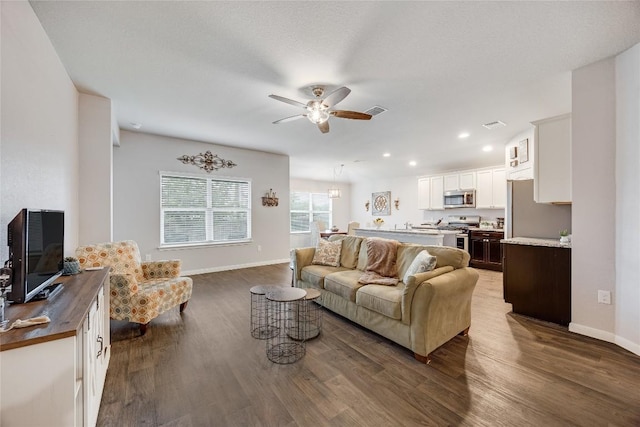 living area featuring a ceiling fan, dark wood finished floors, baseboards, and recessed lighting