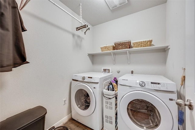 washroom with independent washer and dryer, baseboards, and wood finished floors