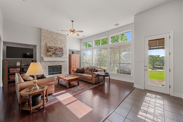 living room with ceiling fan, a fireplace, wood finished floors, and baseboards