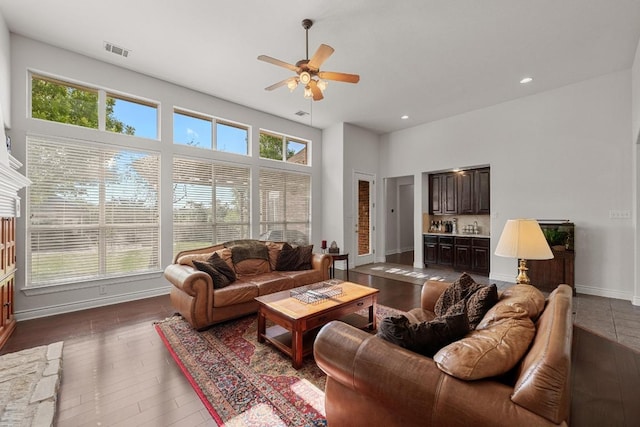 living area with a ceiling fan, healthy amount of natural light, recessed lighting, baseboards, and dark wood finished floors