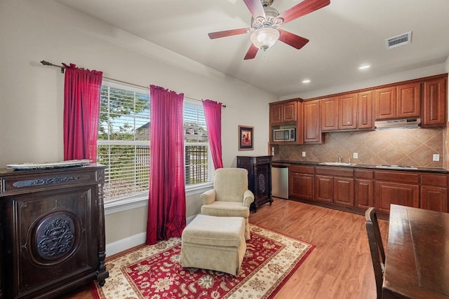 living area featuring light wood finished floors, a ceiling fan, recessed lighting, and baseboards