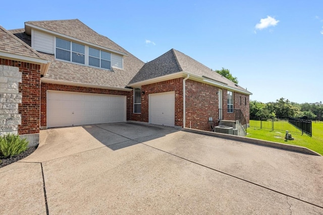 117 Hucks Hideaway, Dripping Springs, TX 78620 - view of property exterior featuring driveway, brick siding, a shingled roof, and an attached garage