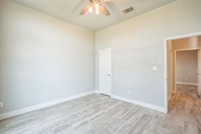 empty room featuring ceiling fan, light wood-type flooring, and baseboards