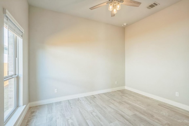 spare room with light wood-style flooring, a ceiling fan, and baseboards