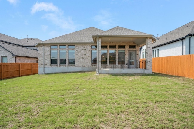 rear view of property with brick siding and a shingled roof