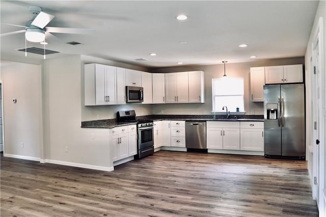 406 Rivers St, Smithville, TX 78957 - kitchen featuring stainless steel appliances, a sink, ceiling fan, dark countertops, and baseboards