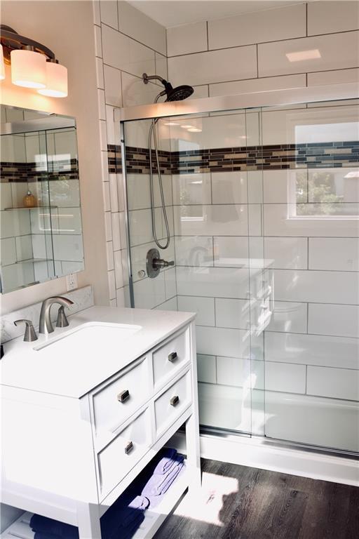406 Rivers St, Smithville, TX 78957 - bathroom featuring a shower stall, wood finished floors, and vanity