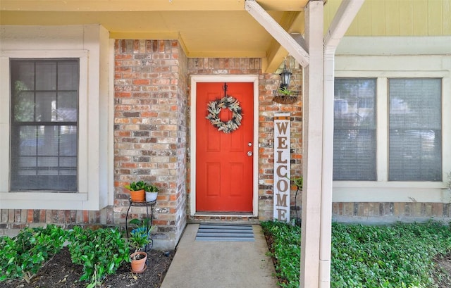 view of exterior entry featuring brick siding