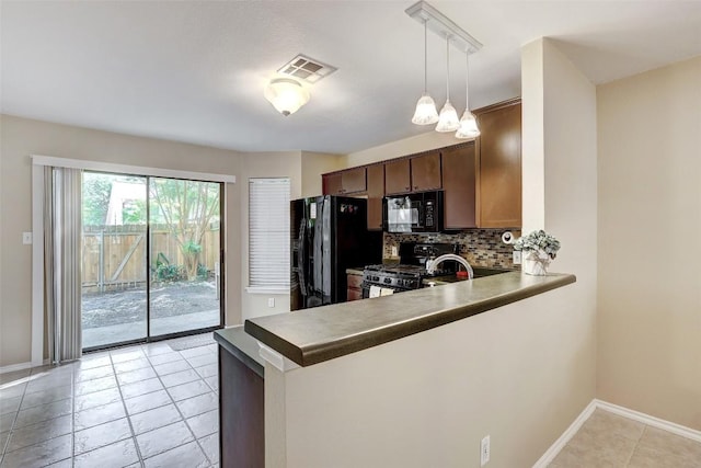 11901 Swearingen Dr Unit 110, Austin, TX 78758 - kitchen with black appliances, backsplash, a peninsula, light tile patterned floors, and decorative light fixtures