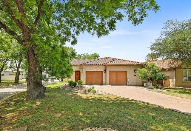 101 Blanco Ct, Horseshoe Bay, TX 78657 - mediterranean / spanish house with a tiled roof, stucco siding, driveway, and an attached garage